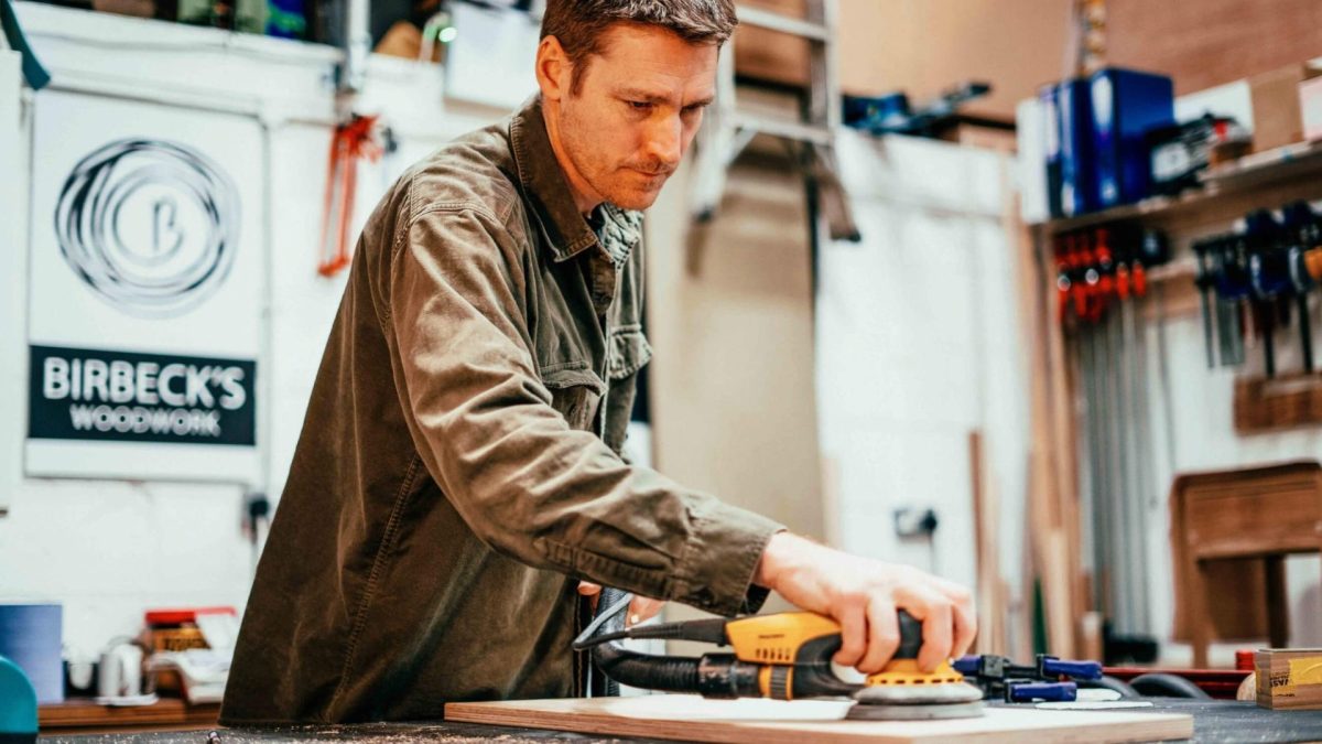 Edinburgh-open-workshop-Master_slide_eow-17 Person in Edinburgh Open Workshop using electrical sander on wood