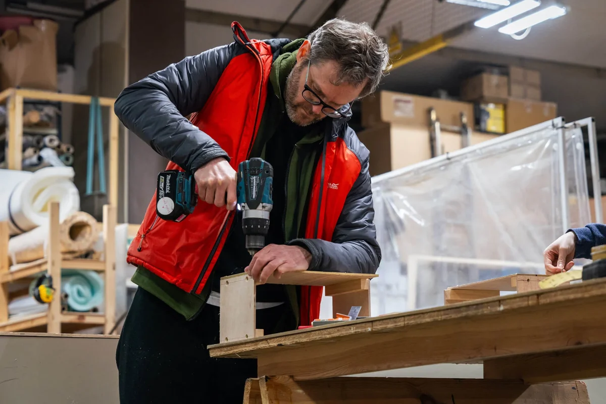 Person carefully drills hole into wooden box