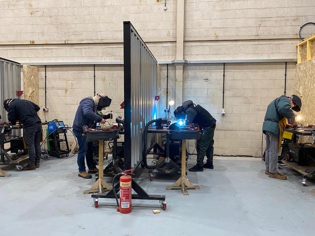 Metal workers at the EOW welding station
