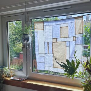 Image of a window with a patchwork style curtain