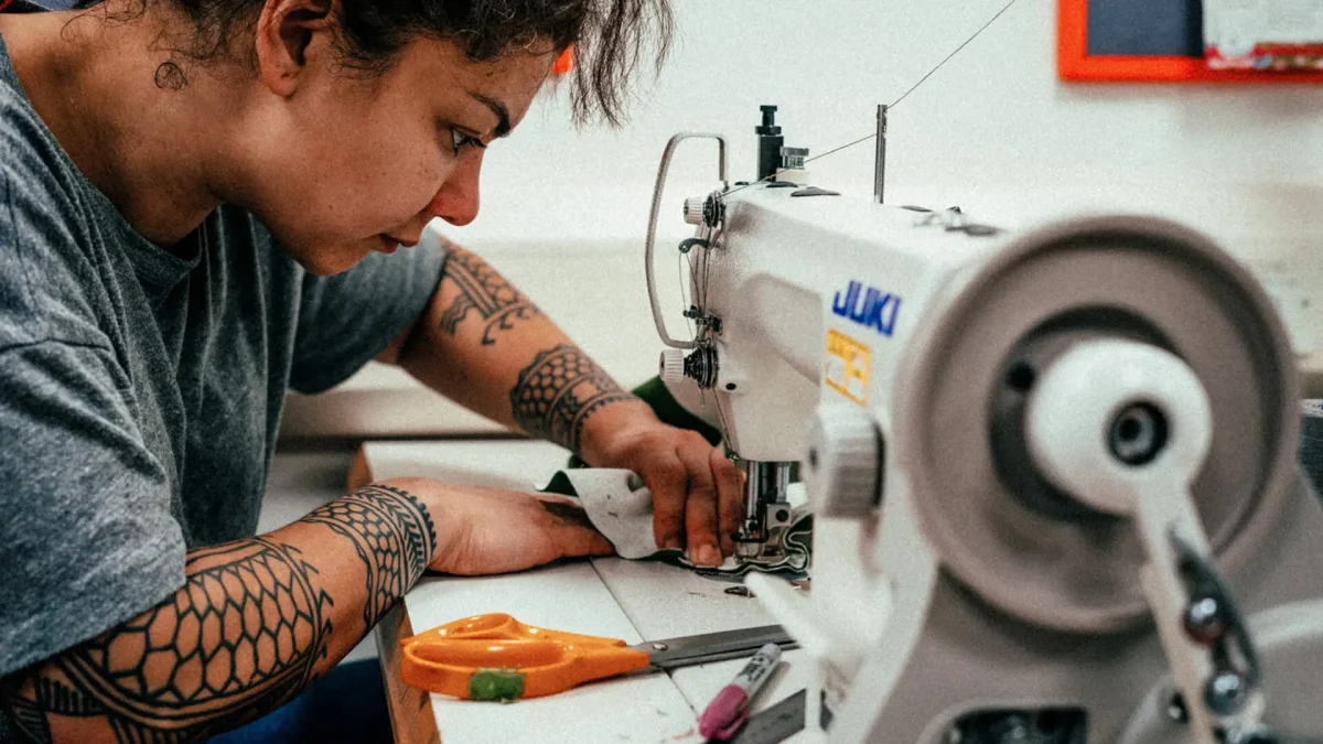 Edinburgh-open-workshop-Master_slide_eow-9-1 Person working closely on sewing machine in Edinburgh Open Workshop