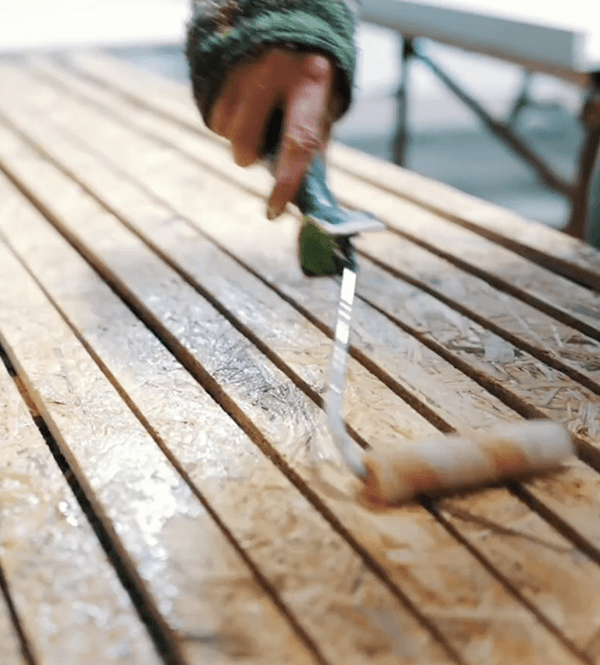paint-floor-poster-image Person using a roller to paint wood